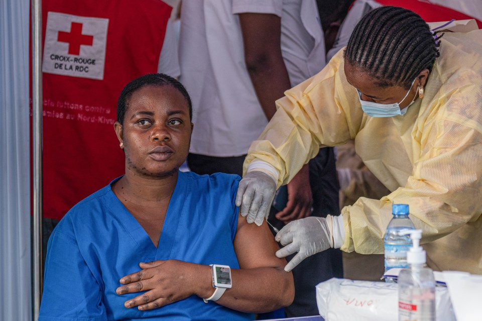 A medical staff receives a vaccine for smallpox and m-pox