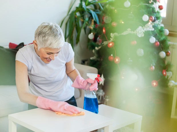 A woman cleaning a table in her living room before Christmas.