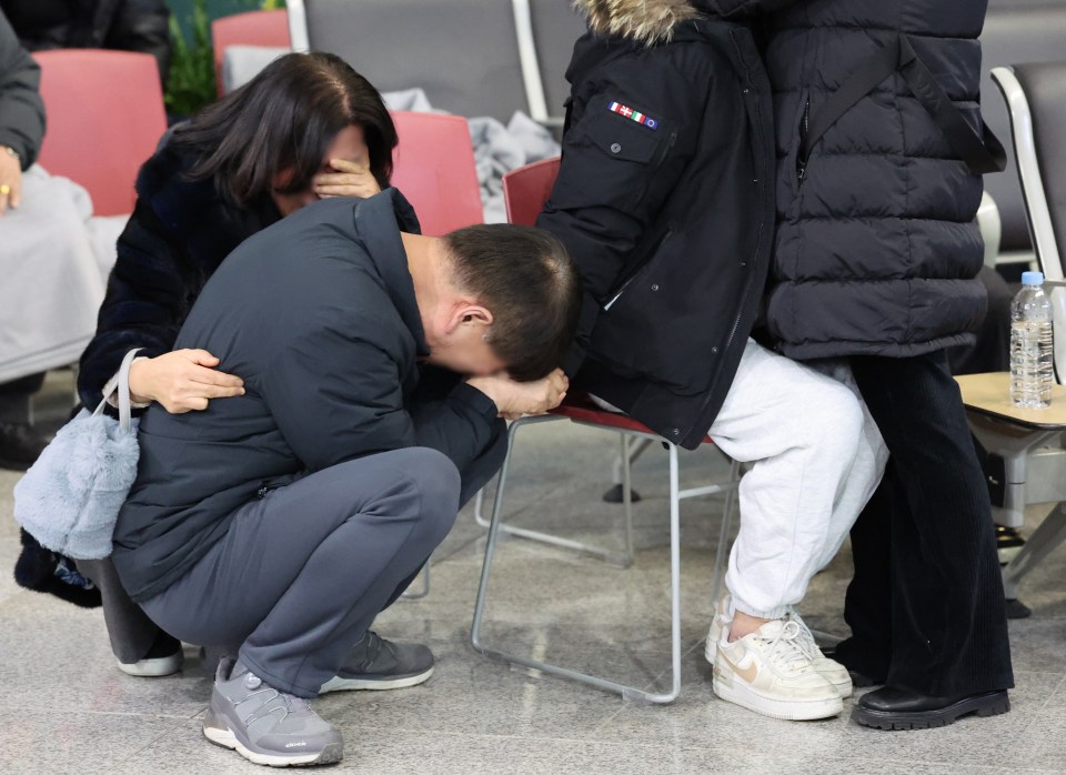 Family members of a victim grieve at the airport