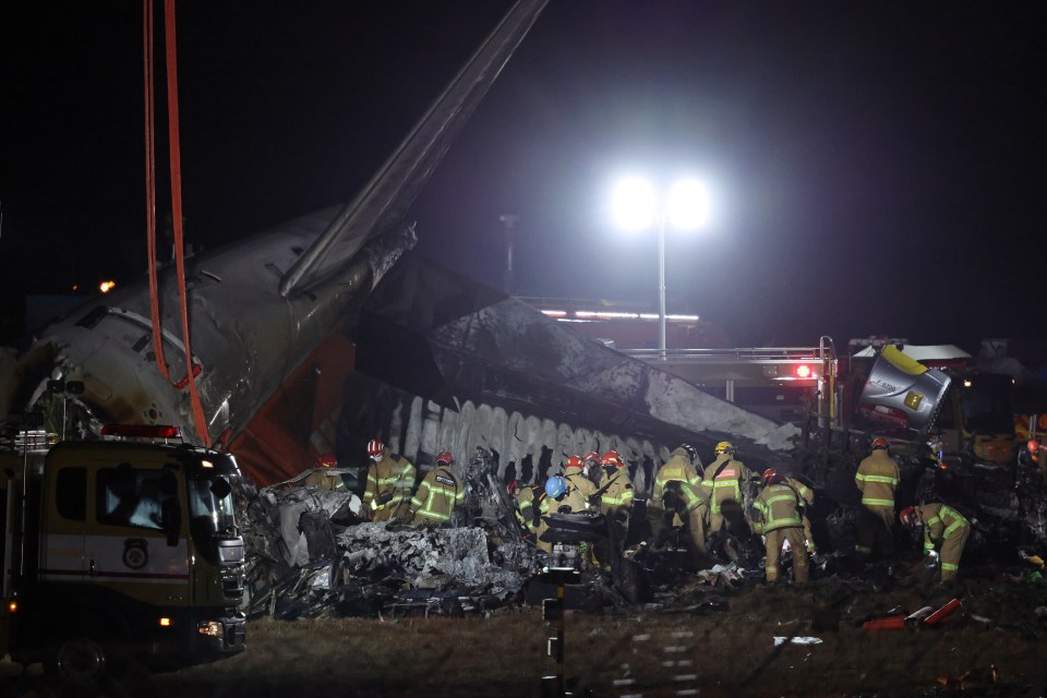 Firefighters work near the wreckage of the Jeju Air aircraft at Muan International Airport