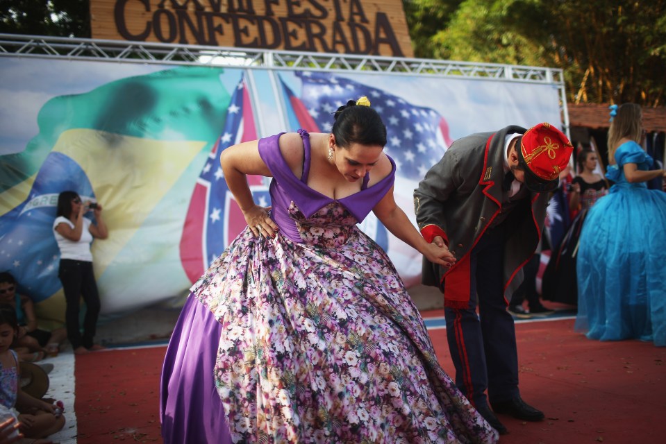 People dressed in traditional outfits take a bow after dancing at the annual Festa Confederada