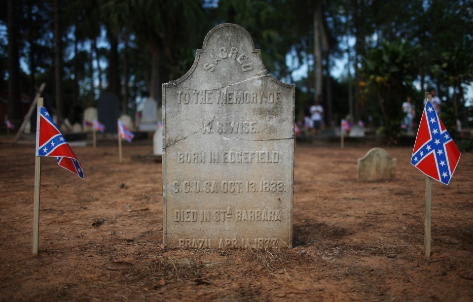 A grave of a U.S. settler is marked with Confederate flags