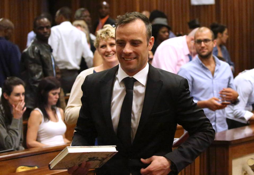 Former Paralympic champion Oscar Pistorius smiles as he leaves the North Gauteng High Court in Pretoria, South Africa