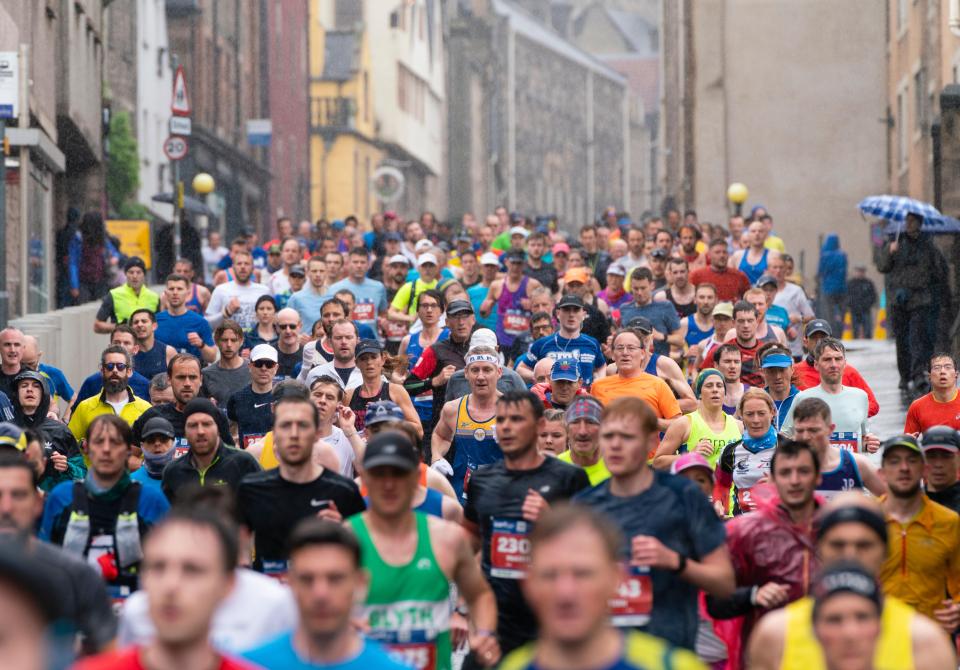 Edinburgh Marathon runners heading down the Royal Mile towards Holyrood