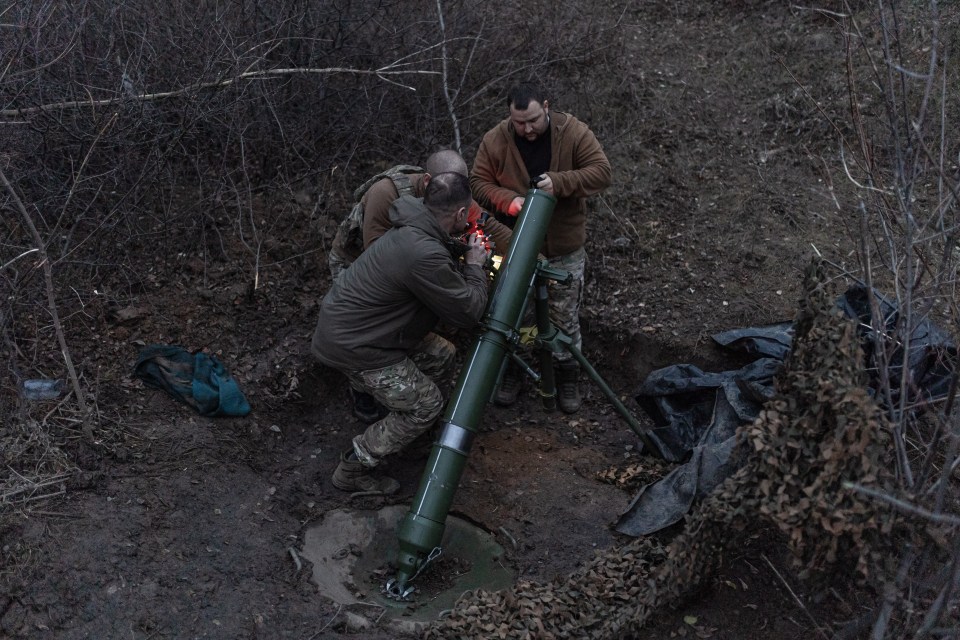 Ukrainian soldiers fire a mortar at Russians