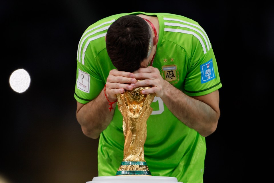 Emiliano Martinez of Argentina embraces the World Cup trophy.