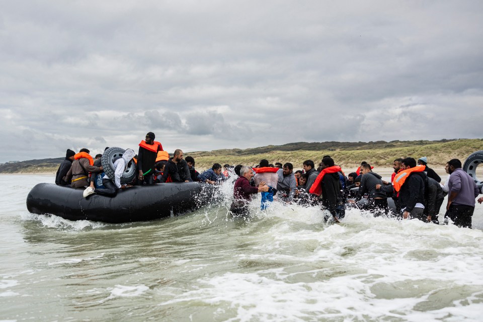 Migrants board a smuggler’s inflatable dinghy in northern France on October 30, 2024