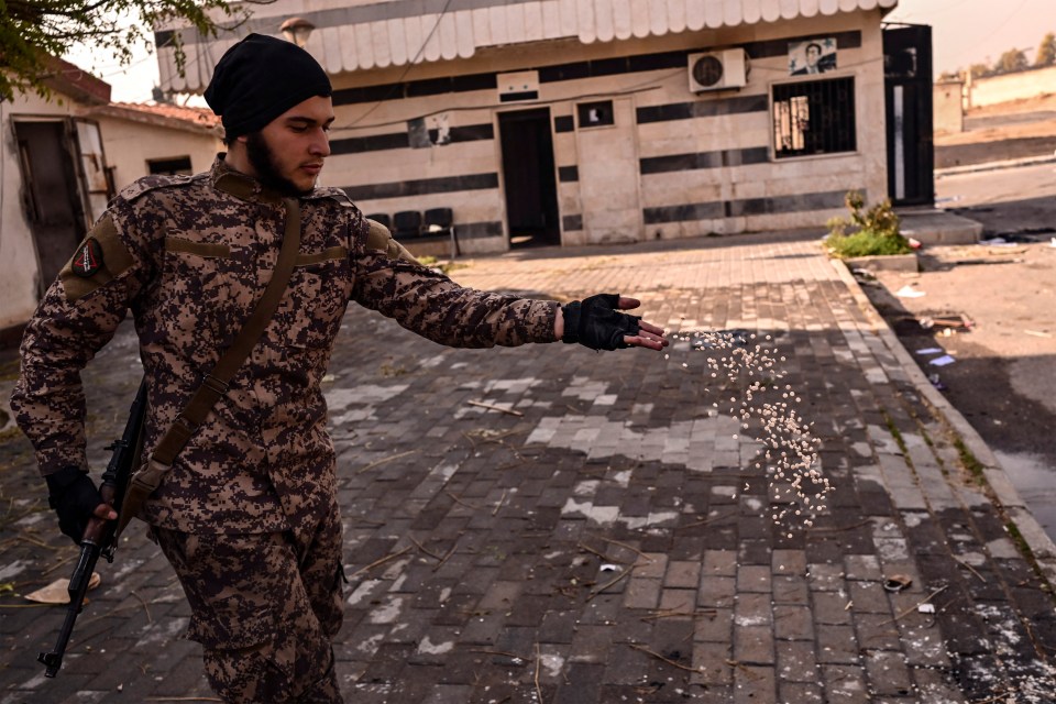 A Syrian rebel fighter throws away the pills