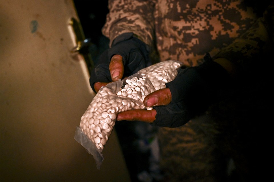 A Syrian rebel fighter holds a bag containing pills of Captagon