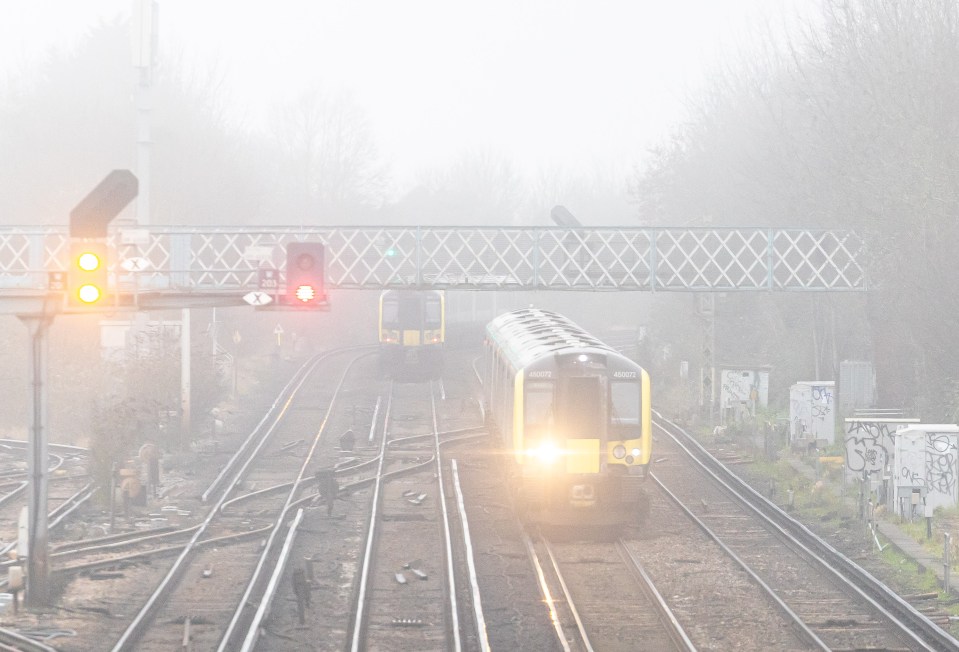 A London bound train to Waterloo Station glides along misty tracks yesterday