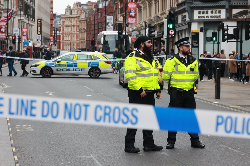 London police officers guard a crime scene cordon.