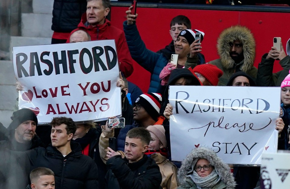 Manchester United fans hold signs showing support for Marcus Rashford.