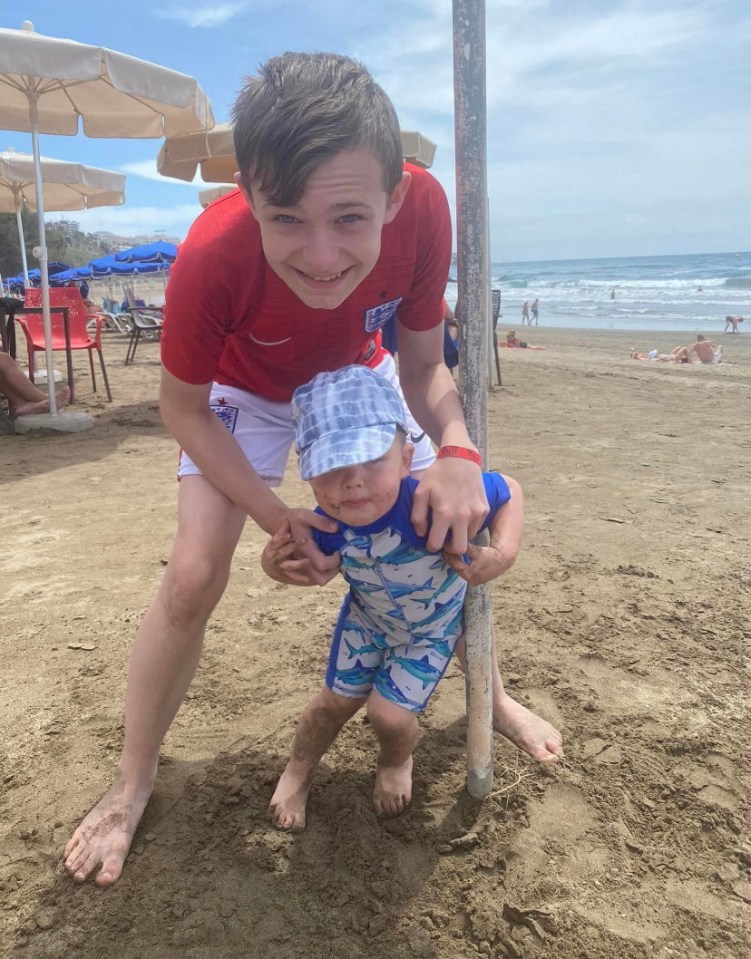 Mason Rist, 15, with his nephew on a beach.