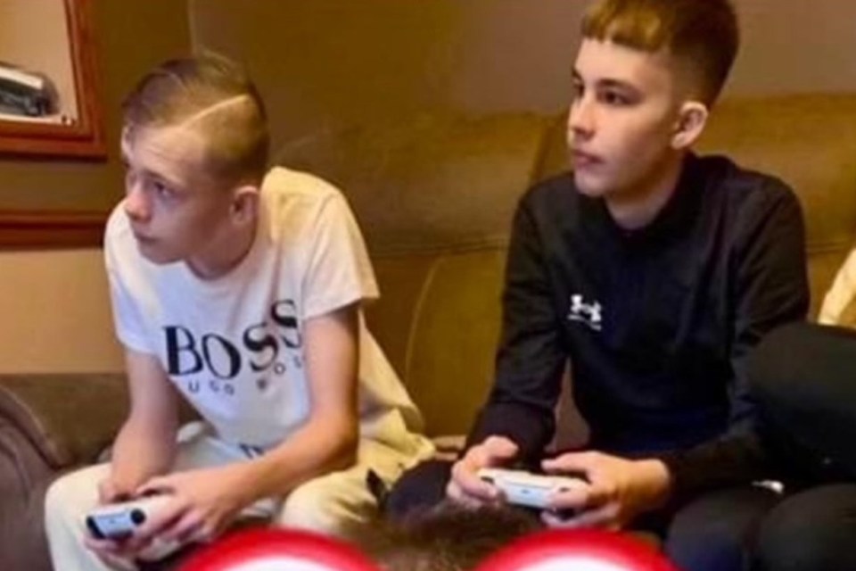 Two teenage boys playing video games.