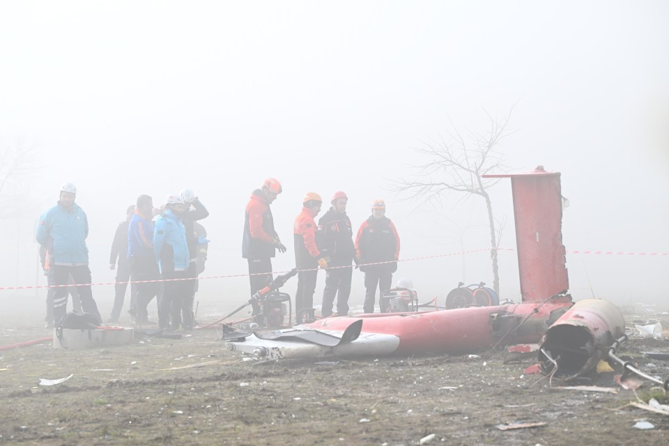 Emergency teams inspect the crashed helicopter on the ground