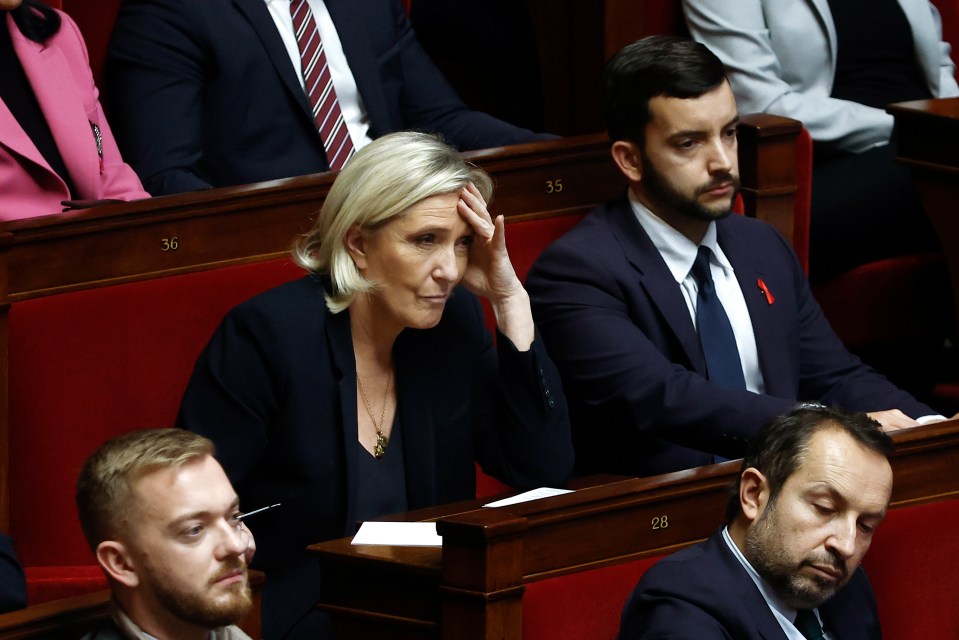 Rassemblement National (RN) parliamentary group President Marine Le Pen (C-L) listens to the speech of the French prime minister during a no-confidence vote against his government at the National Assembly