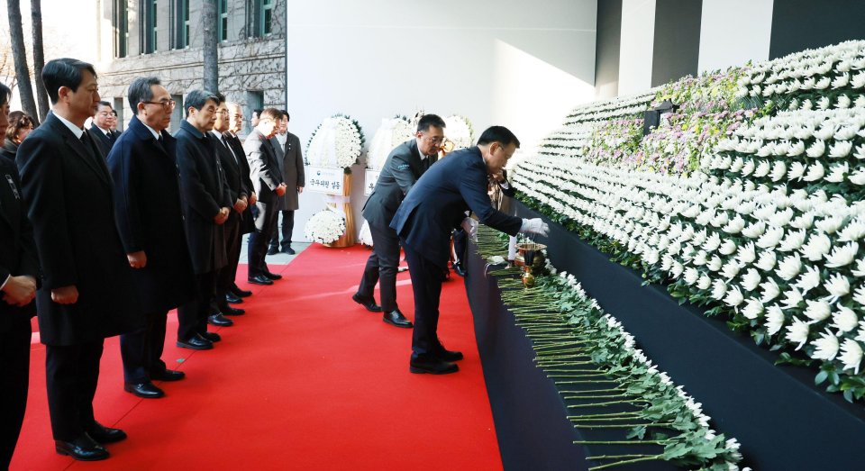 Officials lay flowers in tribute to the victims of the crash