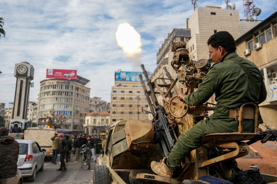 Rebel forces firing a mounted machine gun in a Syrian city.