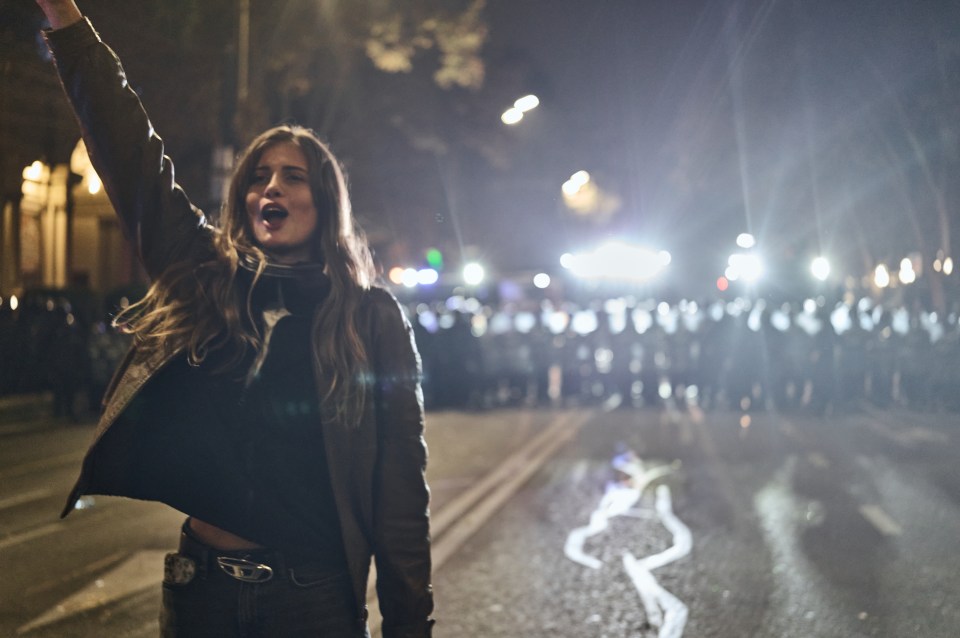 A young woman protests at night in Tbilisi, Georgia.