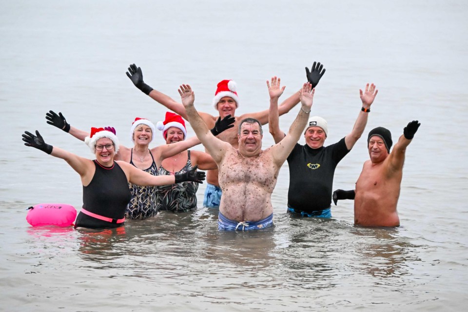 Christmas Day swimmers in Santa hats enjoying a dip in the sea.