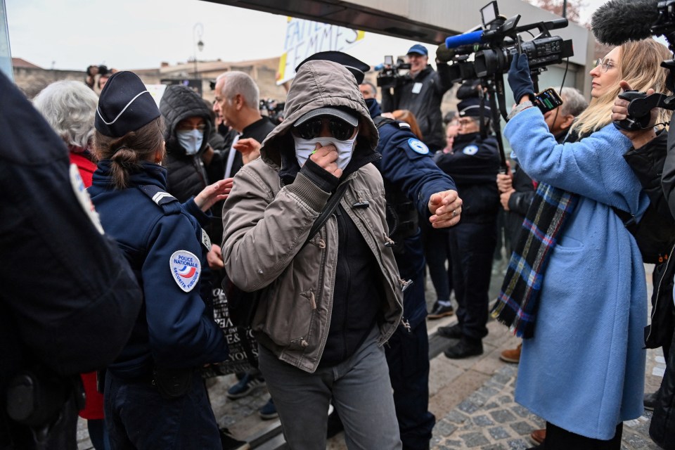 One of the defendant arrives at the courthouse today wearing a mask, baseball cap and hood to hide his identity