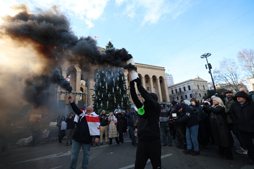 Anti-government protesters using smoke bombs outside the parliament building in Tbilisi.