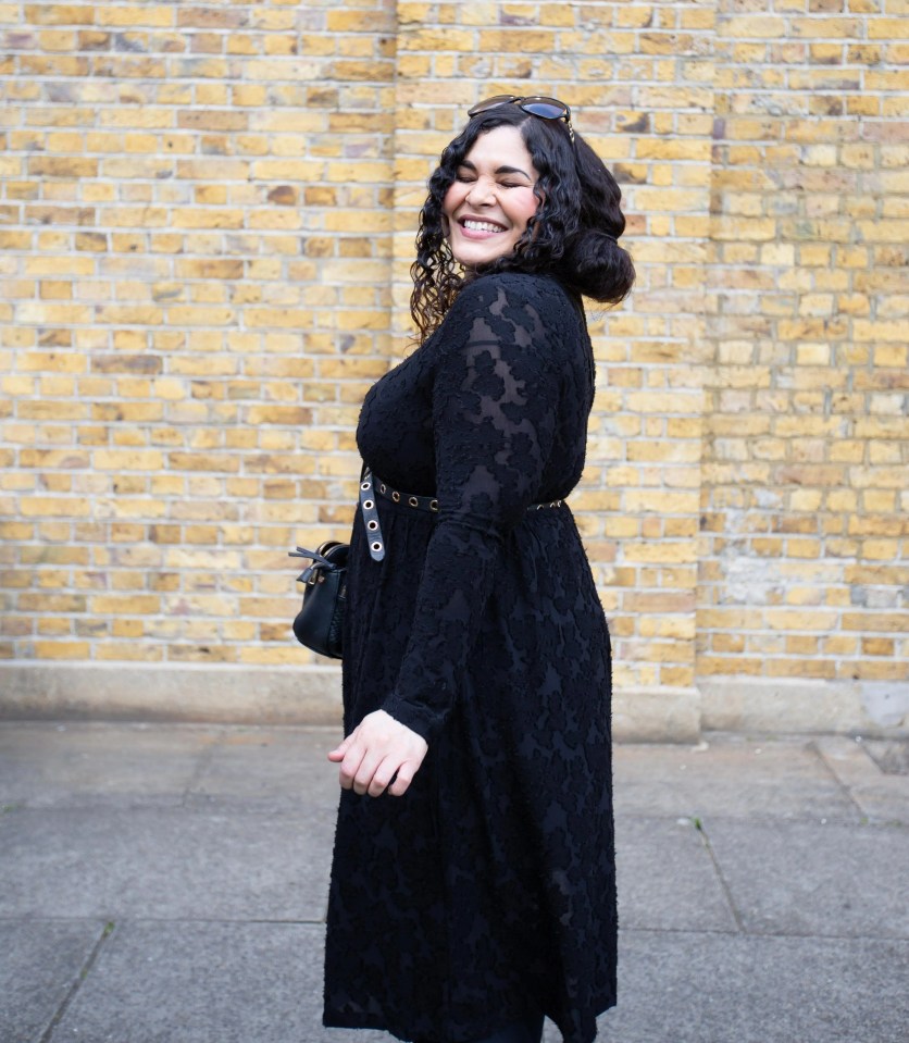 Smiling woman in black dress.