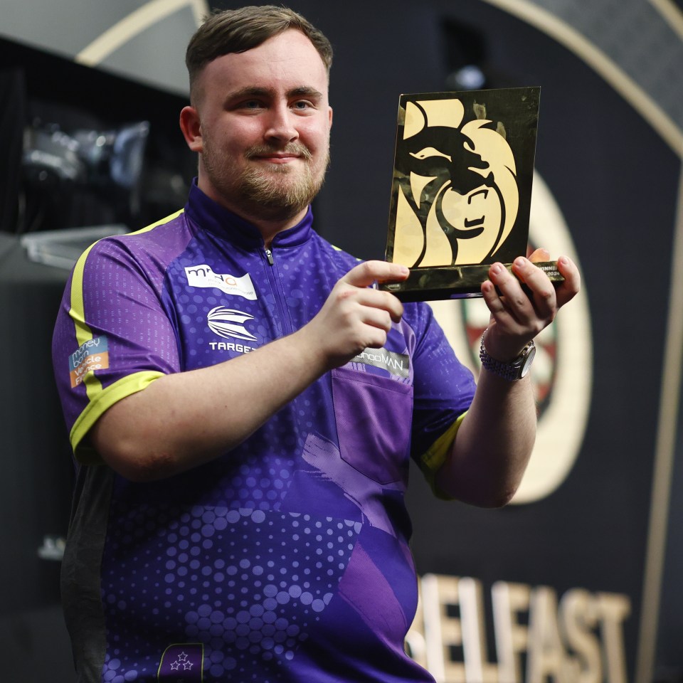 Luke Littler holding a trophy after winning in Belfast.