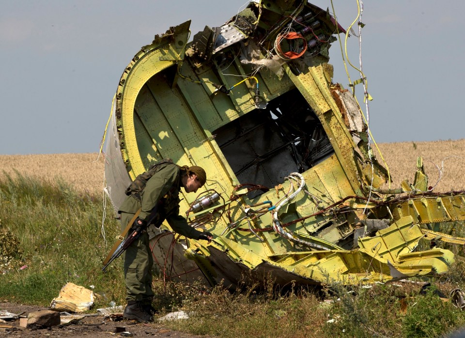 A pro-Russian rebel touches the MH17 wreckage at the crash site on 22 July 2014