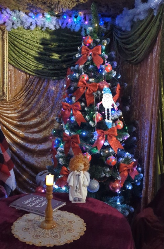 There is a full-size Christmas tree decorated with bauble, bows and lights