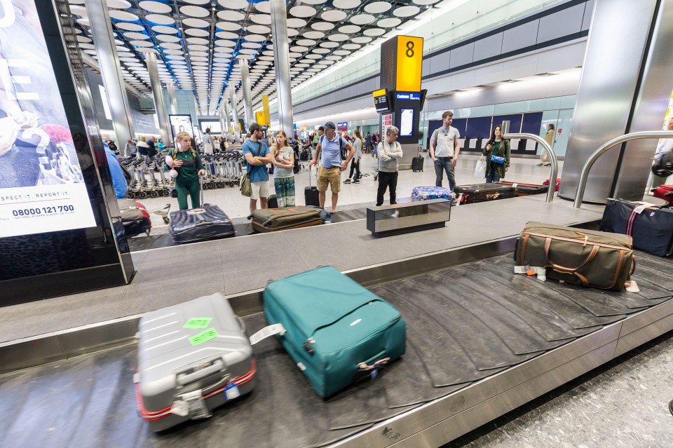 Luggage arriving on a baggage carousel at an airport.