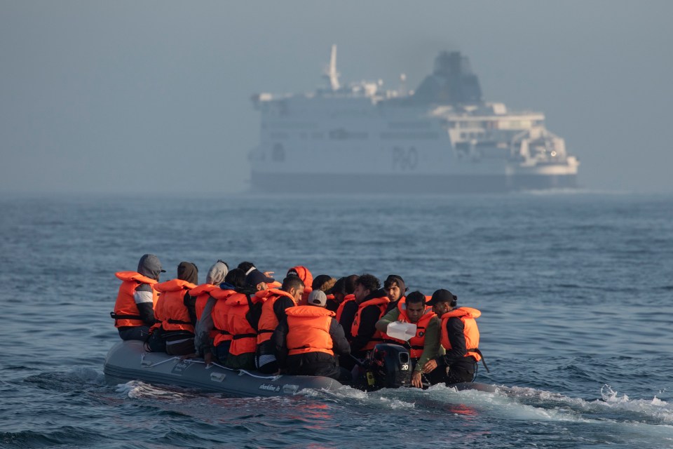 An inflatable craft carrying migrant men, women and children in the English Channel