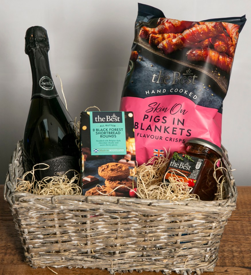 Christmas hamper with champagne, pigs in blankets, shortbread, and chutney.