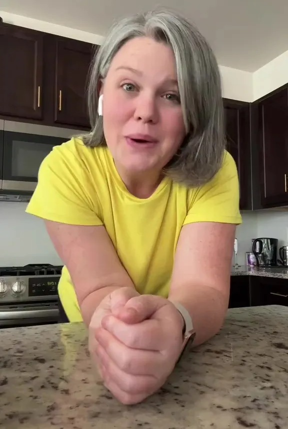 Woman in yellow shirt speaking to camera.