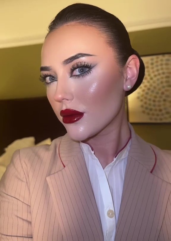 Air stewardess demonstrating her makeup routine, focusing on her red lipstick.