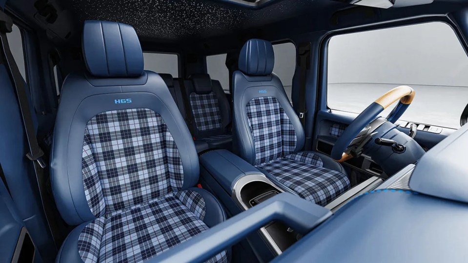 Interior of a custom-made G-Wagon with blue tartan upholstery and wood-inlaid steering wheel.