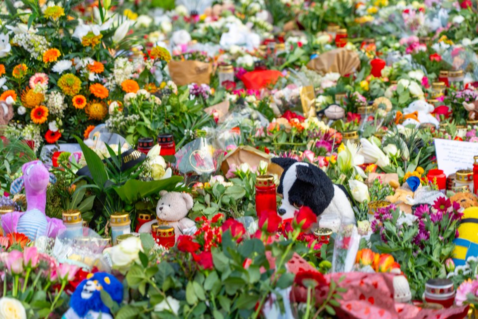 Flowers and toys have all been left at a mural for the victims