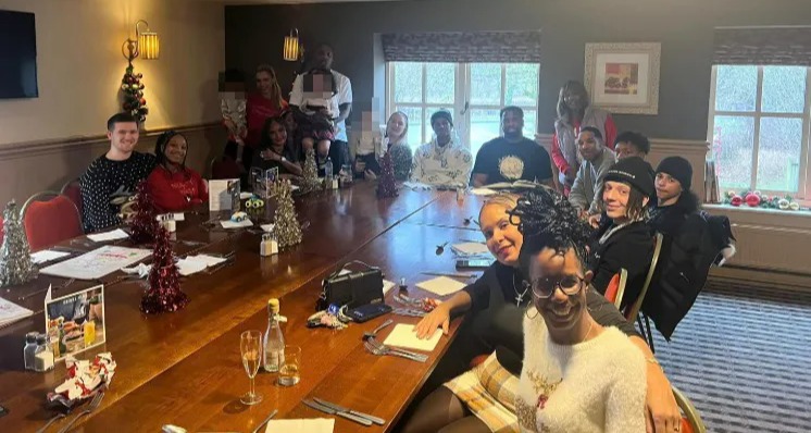 Marcus Rashford with a large group of people at a holiday gathering.