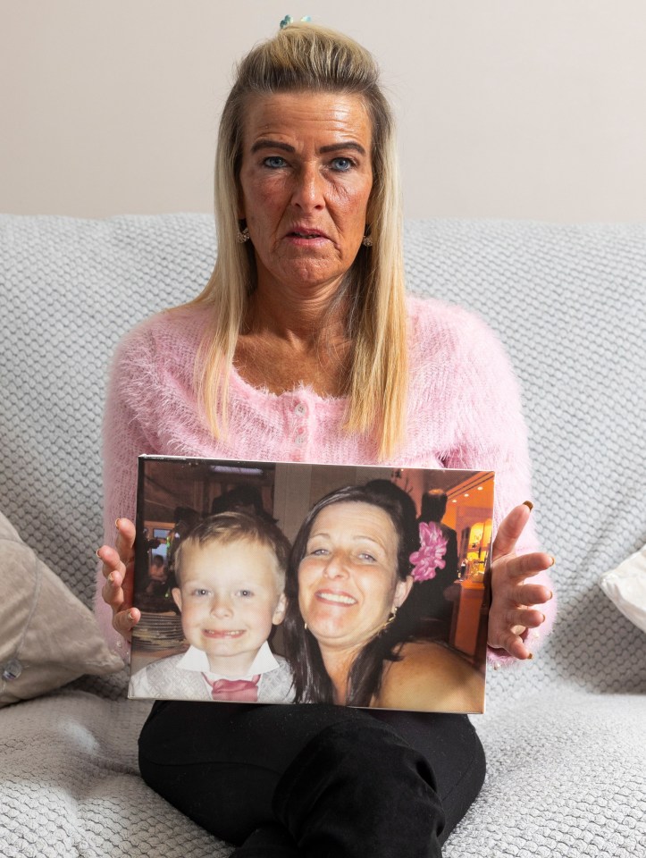 A grieving mother holds a photo of her young son.