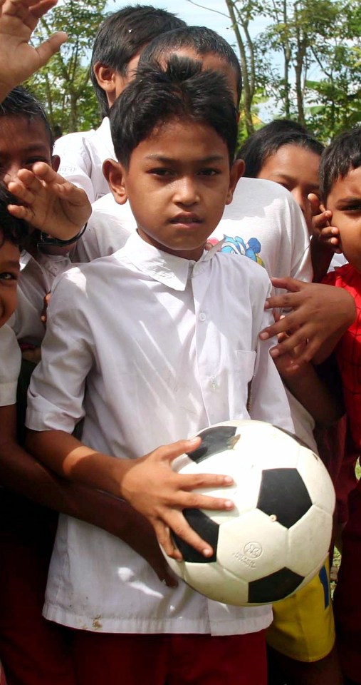 Martunis holding a ball as he poses with his classmates on 5 December 2005