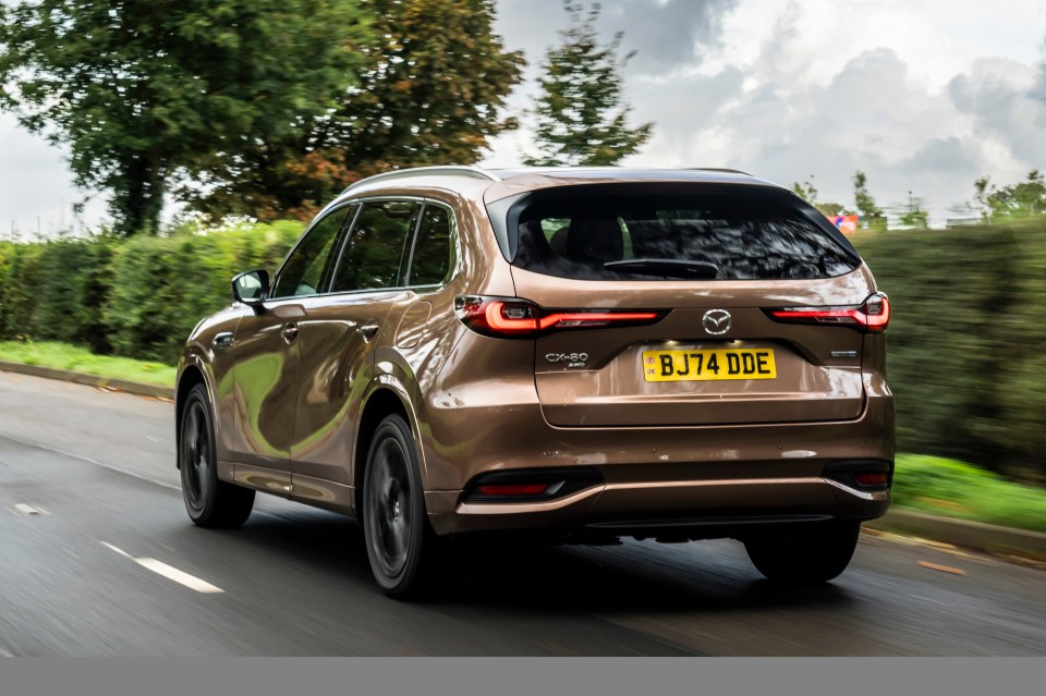 Brown Mazda CX-60 driving on a road.