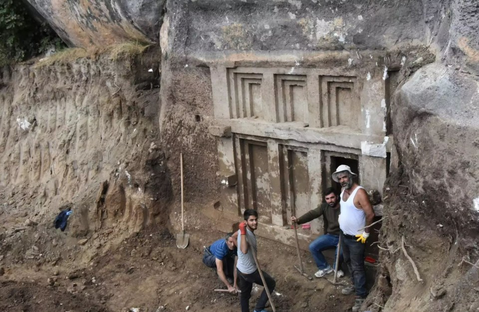 Archaeologists excavating an ancient stone structure.