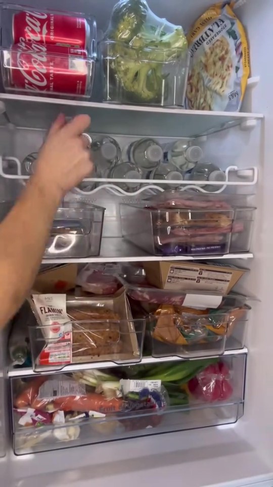 Organized refrigerator with food stored in clear containers.