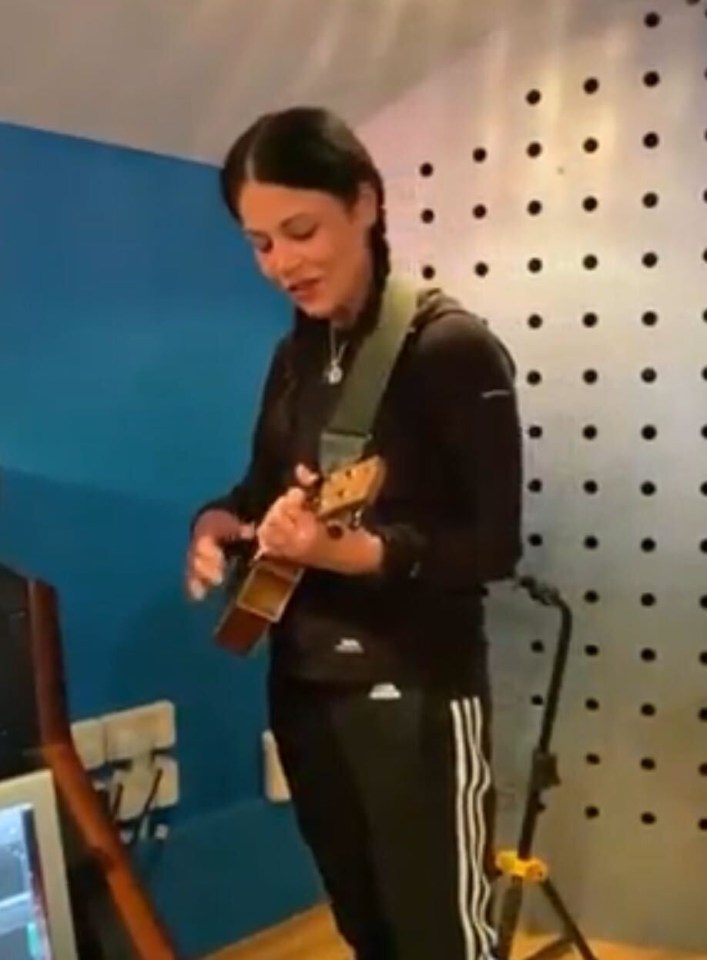 Woman playing ukulele in recording studio.