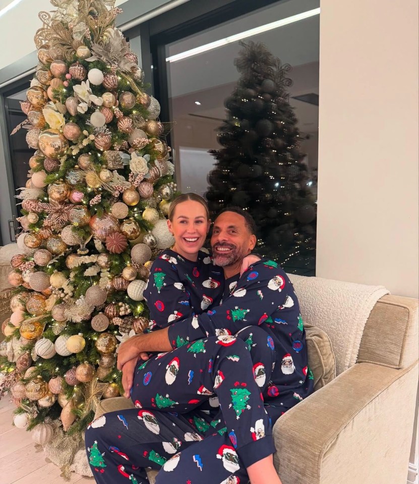 Couple in matching Christmas pajamas by a decorated Christmas tree.