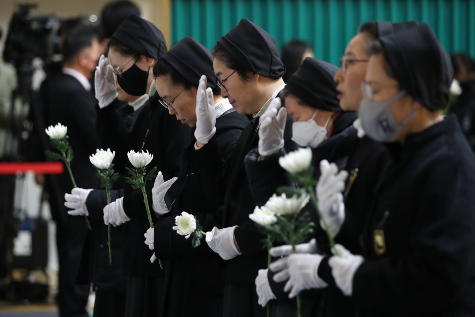 South Korean nuns pay tribute at a group memorial altar