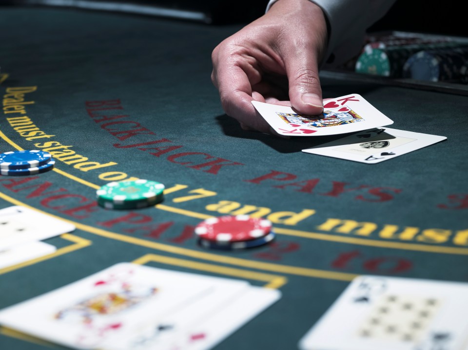 Close-up of a croupier dealing cards at a blackjack table.