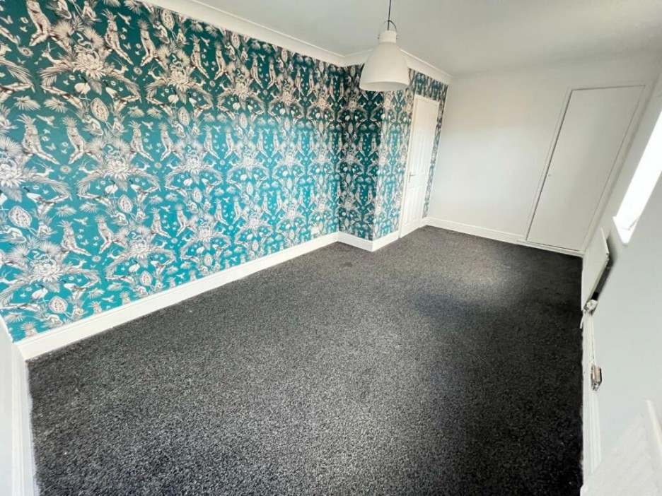 This large bedroom in the Shildon property shows off a colourful feature wall