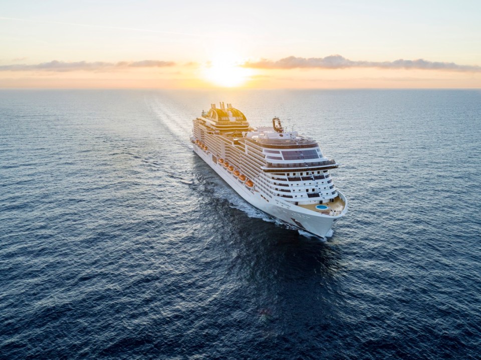 MSC Virtuosa cruise ship sailing at sunset.