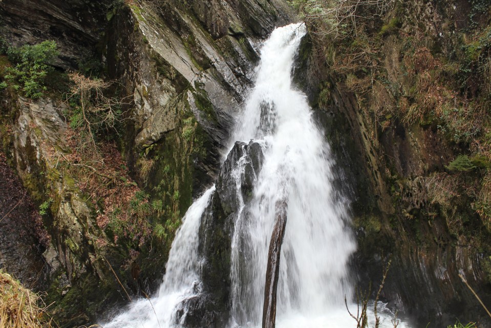 Waterfall cascading down moss-covered rocks.